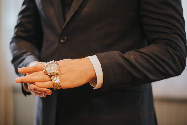 A closeup shot of a businessman in suit putting on his watch - Foto, Imagen