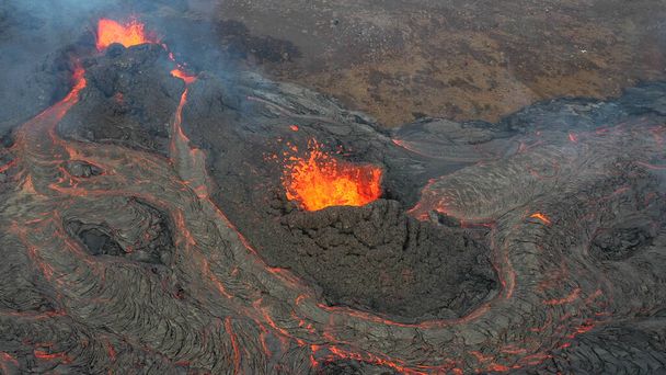 lávafolyam vulkán havas hegyekkel, légi rálátás Forró láva és magma jön ki a kráterből, 2021. április  - Fotó, kép