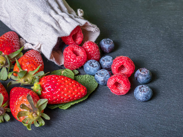 Strawberries, raspberries and blueberries with grey background. Organic food - Φωτογραφία, εικόνα