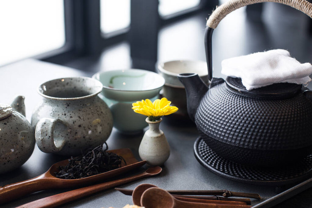Aziatische voedselachtergrond met een theeset, kopjes, theeblaadjes en theepot. - Foto, afbeelding