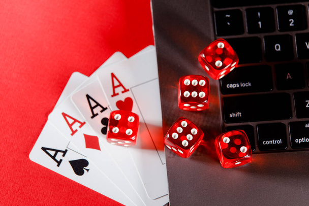 オンラインポーカーカジノのテーマ。赤い背景でトランプやダイスを再生する - 写真・画像