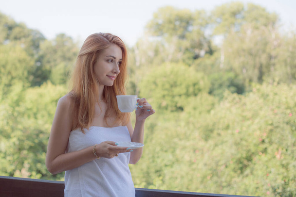 Όμορφο πρωινό στο σπίτι, κορίτσι με ένα φλιτζάνι καφέ, έννοια του τρόπου ζωής των σύγχρονων ανθρώπων - Φωτογραφία, εικόνα