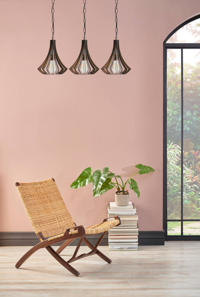 ウィッカーチェアと植物、ランプの装飾スタイルのピンクの壁の部屋. - 写真・画像