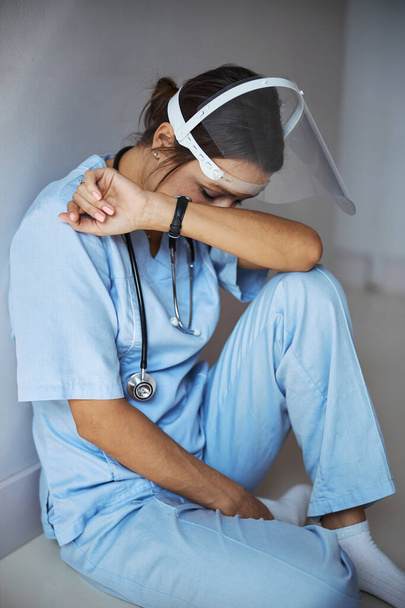 Müde Ärztin sitzt in Klinik auf dem Fußboden - Foto, Bild