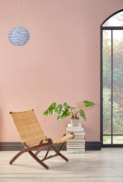 Hasır sandalyesi ve bitkisi olan pembe duvar odası, lamba dekorasyonu tarzı.. - Fotoğraf, Görsel