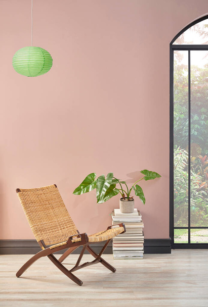 Quarto de parede rosa com cadeira de vime e planta, estilo de decoração da lâmpada. - Foto, Imagem