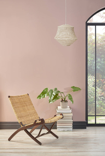 Habitación de pared rosa con silla de mimbre y planta, estilo de decoración de la lámpara. - Foto, Imagen