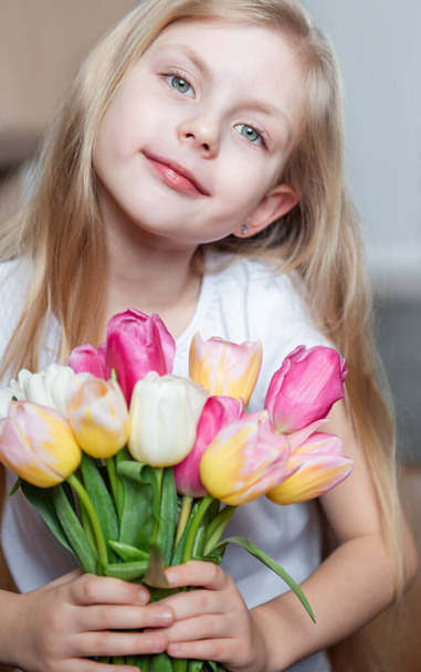 Spring tulips in the hands of a little girl. Mother's day gift. - Fotografie, Obrázek