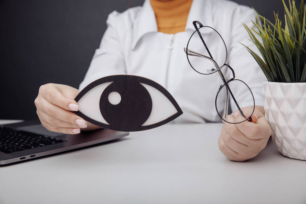 Olho de madeira e óculos em mãos de médicos close-up - Foto, Imagem