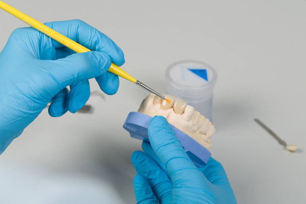 közeli-ból festészet munka mesterséges fogászati ecsettel egy fogászati laboratóriumban - Fotó, kép
