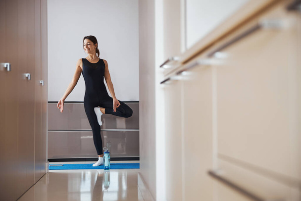 Iloinen urheilullinen nainen harjoittelee joogaa kotona - Valokuva, kuva