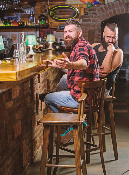 Hipster brutal bearded man spend leisure with friend at bar counter. Men relaxing at bar. Friday relaxation in bar. Friendship and leisure. Friends relaxing in pub. Order drinks at bar counter - Foto, afbeelding