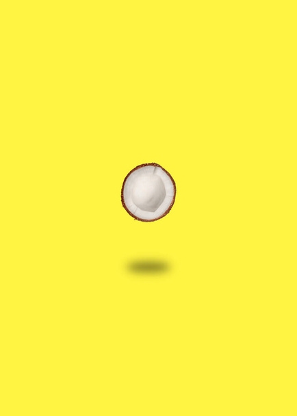 Один стиглий кокос на жовтому тлі. Плоский простір, вид зверху. Літня концепція
. - Фото, зображення
