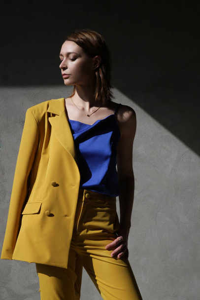 Fashionable young woman in yellow tailored suit. - Foto, immagini