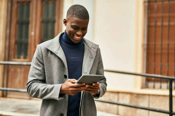 Mladý africký Američan se šťastně usmívá pomocí touchpad ve městě - Fotografie, Obrázek