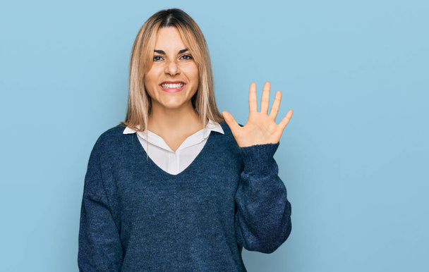 Молодая белая женщина в повседневной одежде показывает и показывает пальцами номер пять, улыбаясь уверенно и счастливо.  - Фото, изображение