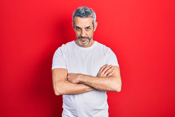 Handsome middle age man with grey hair wearing casual white t shirt skeptic and nervous, disapproving expression on face with crossed arms. negative person.  - Φωτογραφία, εικόνα