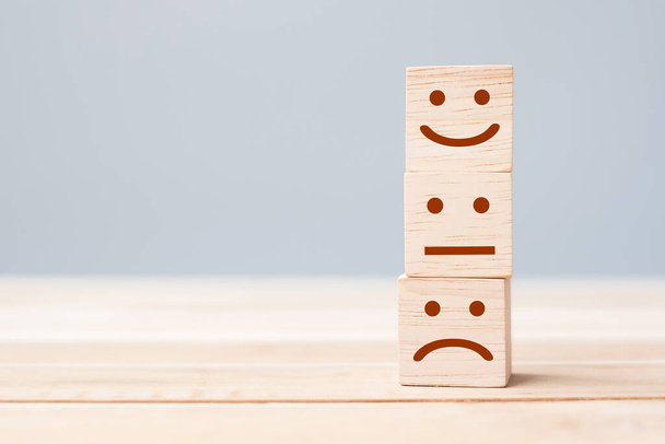 Uśmiechnij się symbol twarzy na żółtych drewnianych blokach sześcianu. Emocje, ocena usług, ranking, ocena klientów, zadowolenie i opinia - Zdjęcie, obraz