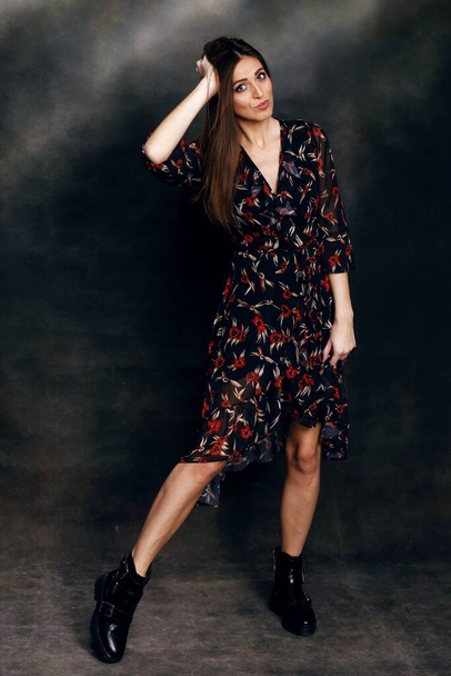 Beautiful, positive brunette girl posing in studio on canvas background. Relaxation, elegance, fashion concept. - Φωτογραφία, εικόνα