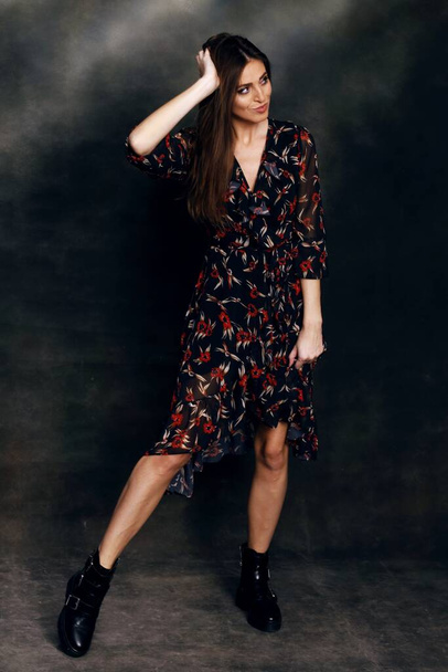 Beautiful, positive brunette girl posing in studio on canvas background. Relaxation, elegance, fashion concept. - Фото, зображення