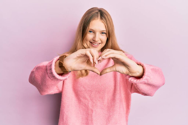 Beautiful young caucasian girl wearing casual clothes smiling in love doing heart symbol shape with hands. romantic concept.  - Photo, Image