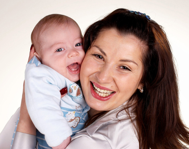 La femme heureuse avec le petit enfant riant sur les mains
 - Photo, image