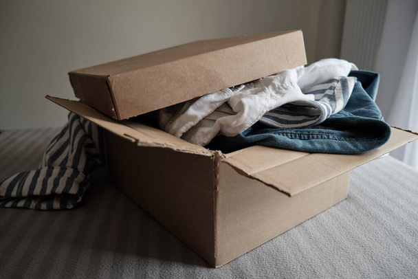 Card box with clothes inside. Sustainable fashion, Clothing swap - Фото, зображення