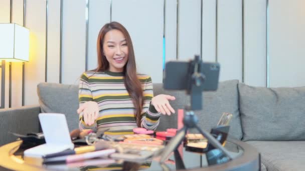 des images de belle femme asiatique faisant maquillage et blogging avec smartphone - Séquence, vidéo
