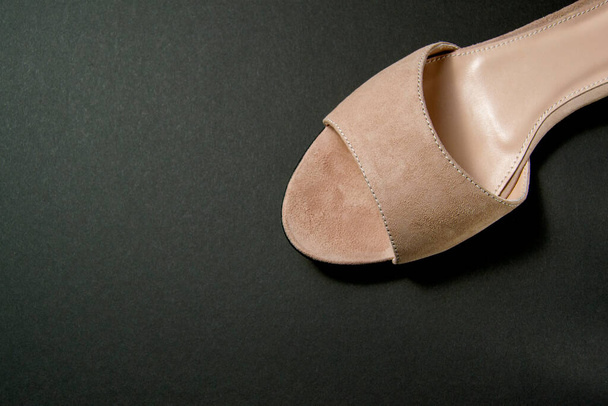 women's shoes of beige color on a black background. shoes removed from the top. shoes are at an angle relative to the horizon - Photo, Image