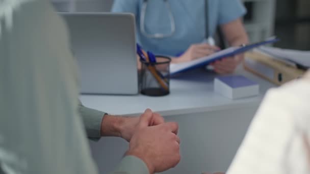 aviopari lääkärin vastaanotolla keskustelemassa terveydentilasta sairaalan toimistossa, kädet lähikuva - Materiaali, video