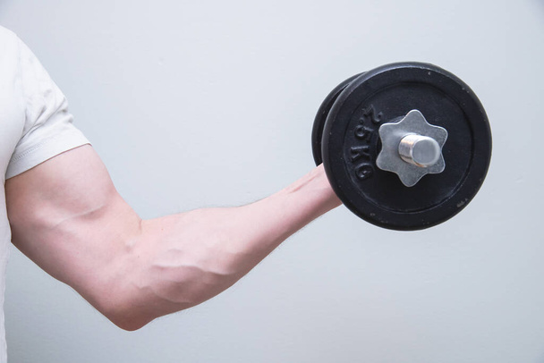 A closeup shot of a male lifting weights on a white background - Photo, Image
