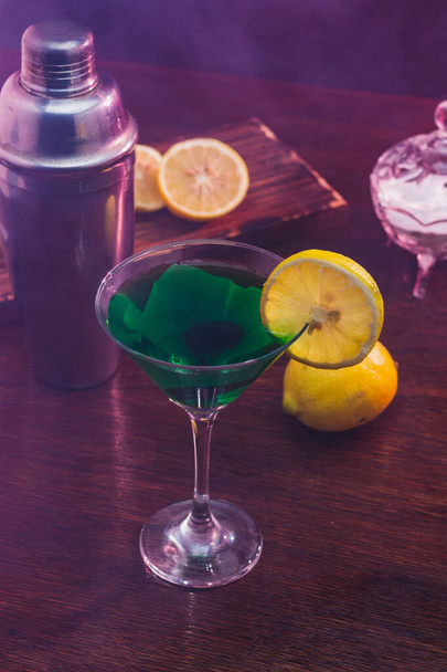A vertical shot of a tasty cocktail with lemons in a bar - Fotó, kép