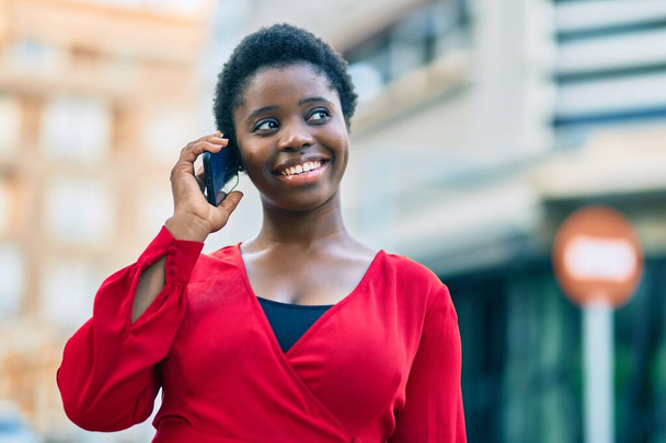 Young african american woman smiling happy talking on the smartphone at the city. - Foto, Imagem