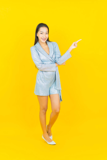 Portrait beautiful young asian woman smile with action on yellow color background - Fotoğraf, Görsel