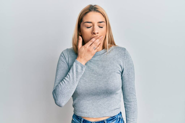 Young caucasian woman wearing casual clothes bored yawning tired covering mouth with hand. restless and sleepiness.  - Foto, Bild