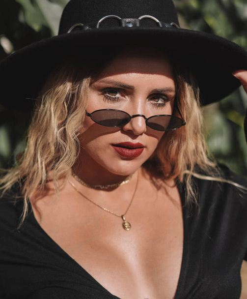 Portrait of an alternative blonde model with hat and sunglasses - Foto, imagen
