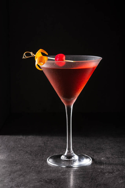 Traditional Manhattan cocktail with cherry on black background - Fotoğraf, Görsel