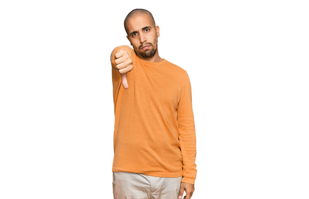 Hispanic adult man wearing casual winter sweater looking unhappy and angry showing rejection and negative with thumbs down gesture. bad expression.  - Valokuva, kuva