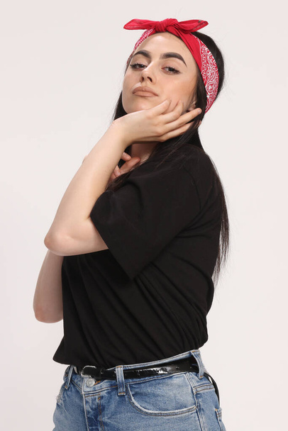 Όμορφη λευκή χίπστερ κοπέλα με μαύρα μαλλιά και γυαλιά ποζάρει στο στούντιο σε απομονωμένο φόντο. Στυλ, τάσεις, έννοια της μόδας. - Φωτογραφία, εικόνα