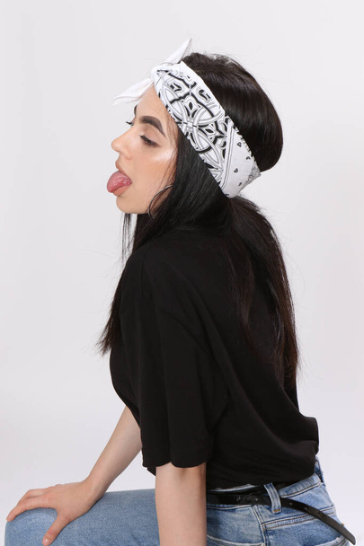 Красивая кавказская хипстерша с черными волосами и очками позирует в студии на изолированном фоне. Стиль, тенденции, концепция моды. - Фото, изображение