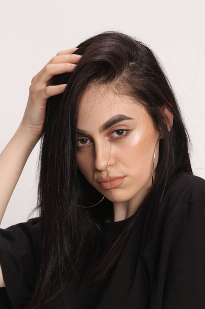 Красивая кавказская хипстерша с черными волосами и очками позирует в студии на изолированном фоне. Стиль, тенденции, концепция моды. - Фото, изображение