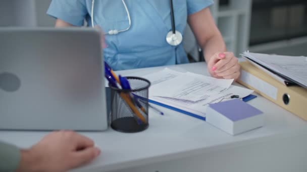 ženský lékař během konzultace s manželským párem dává negativní test na koronavirus v nemocniční ordinaci, detailní záběr - Záběry, video