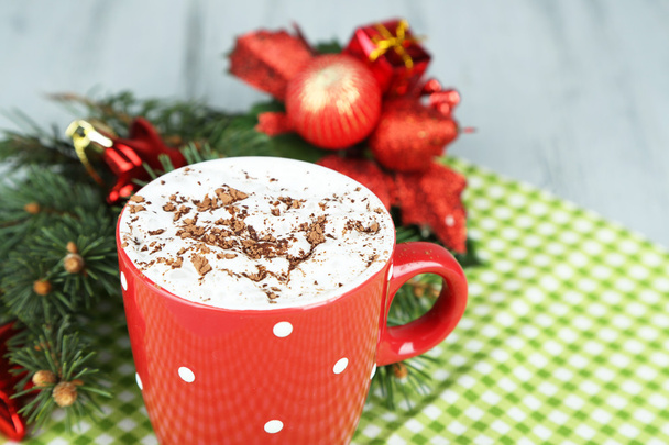 Hot chocolate with cream in color mug, on napkin, on Christmas decorations background - Valokuva, kuva