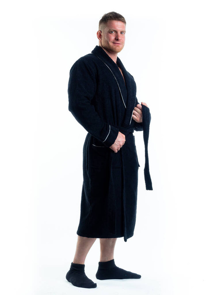 strong man in a Bathrobe on an isolated white background with a smile on his face. Shot in the Studio in full growth. - Zdjęcie, obraz