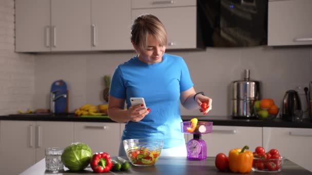 Zayıflayan kadın mutfakta sebze tartıyor. - Video, Çekim