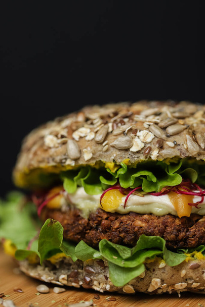Primer plano de jugosa hamburguesa vegetariana saludable en plato de madera - Foto, imagen