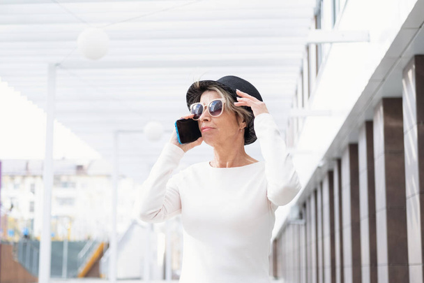 Divat üzlet vezető vonzó nő séta telefonnal a városban - Fotó, kép