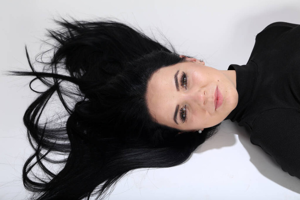 Jolie fille européenne aux cheveux noirs et lunettes posant en studio sur fond isolé. Style, tendances, concept de mode. - Photo, image