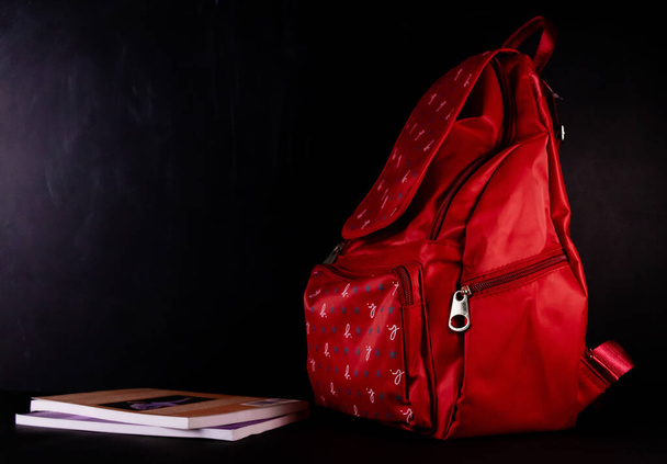 Een schooltas met boeken aan de ene kant geplaatst, geschoten tegen schoolbord op de achtergrond -Basisonderwijs concept - Foto, afbeelding