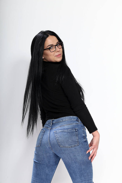 Attractive european girl with black hair and glasses posing in studio on isolated background. Style, trends, fashion concept. - Photo, Image